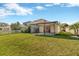View of a backyard with green grass and a screened-in porch at 7806 Grasmere Dr, Land O Lakes, FL 34637