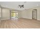 Bright living area with hardwood floors, sliding glass doors to the outside, and ceiling fan at 7806 Grasmere Dr, Land O Lakes, FL 34637
