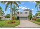 Two-story house with gray siding, attached garage, and palm trees at 1118 2Nd S Ave, Tierra Verde, FL 33715