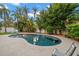 Kidney shaped pool with surrounding patio and lush landscaping at 1118 2Nd S Ave, Tierra Verde, FL 33715