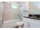 Bathroom with marble tile, glass shower door, combo tub/shower, and updated vanity at 803 W Sligh Ave, Tampa, FL 33604