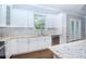 Well-lit modern kitchen featuring granite countertops, white cabinetry, and stainless steel appliances at 803 W Sligh Ave, Tampa, FL 33604