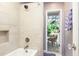 Bathroom with tiled shower and access to screened patio at 12917 Rain Forest St, Temple Terrace, FL 33617