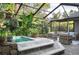 Tranquil patio with spa, seating area, and abundant tropical plants at 12917 Rain Forest St, Temple Terrace, FL 33617