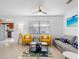 Living room with yellow chairs, gray sofa, and flat screen TV at 13426 Gulf Blvd, Madeira Beach, FL 33708