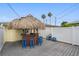 Relaxing tiki bar with thatched roof and blue stools at 13426 Gulf Blvd, Madeira Beach, FL 33708