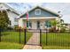 Beautiful home with a black metal fence, manicured lawn, and covered front porch at 445 29Th N Ave, St Petersburg, FL 33704