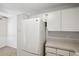 White kitchen with refrigerator and ample cabinet space at 12141 Spartan Way # 103, Hudson, FL 34667