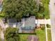 Aerial view of a charming two-story home featuring a lush, green lawn, mature trees and a private driveway at 6619 Livingston N Ave, St Petersburg, FL 33702