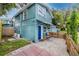 Rear view of home showing the entrance, small patio with chairs, and well-maintained exterior at 6619 Livingston N Ave, St Petersburg, FL 33702