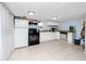 Functional kitchen with white cabinets, stainless steel appliances, tile floor, and adjacent space for appliances at 6619 Livingston N Ave, St Petersburg, FL 33702