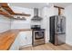 Well-lit kitchen with wood countertops, stainless steel appliances, and ample cabinet space at 6619 Livingston N Ave, St Petersburg, FL 33702