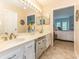 Double vanity bathroom with a large mirror and tiled floor at 9 Pelican Pl, Belleair, FL 33756