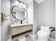Modern bathroom with a floating vanity and a large round mirror at 12506 Ashdown Dr, Odessa, FL 33556