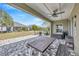 Covered back porch with ceiling fan and brick flooring overlooking the backyard at 16462 Courtyard Loop, Land O Lakes, FL 34638
