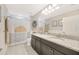 Well-lit bathroom with granite double vanity, decorative shower curtain and modern fixtures at 16462 Courtyard Loop, Land O Lakes, FL 34638
