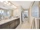 Primary bathroom boasts dual sinks with granite countertops, a walk-in shower, and ample cabinet space at 16462 Courtyard Loop, Land O Lakes, FL 34638