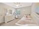 A cheerful bedroom features a bed with pillows, decorative mirror, and a bright unicorn painting at 16462 Courtyard Loop, Land O Lakes, FL 34638