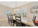 Elegant dining room with large windows, a modern chandelier, and seating for eight at 16462 Courtyard Loop, Land O Lakes, FL 34638