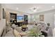 Spacious living room features a large sectional sofa, a decorative ceiling fan, and a built-in entertainment center at 16462 Courtyard Loop, Land O Lakes, FL 34638