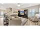 Cozy living room with large sectional sofa, entertainment center, and neutral decor at 16462 Courtyard Loop, Land O Lakes, FL 34638