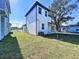 Side view of two-story house with gray exterior and grassy backyard at 2404 1/2 E Chelsea, Tampa, FL 33610