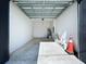 Unfinished garage with open overhead door and concrete floor at 2404 1/2 E Chelsea, Tampa, FL 33610