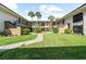 Two-story condo building with landscaped courtyard and walkway at 2700 Nebraska Ave # 4-103, Palm Harbor, FL 34684