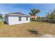 Backyard features lawn, white house, dark roof and blue skies at 2911 E 20Th Ave, Tampa, FL 33605