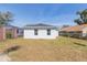 Backyard features lawn, white house with dark roof and blue skies at 2911 E 20Th Ave, Tampa, FL 33605