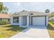 Charming home featuring a white exterior, well-manicured lawn, and an attached single car garage at 2911 E 20Th Ave, Tampa, FL 33605