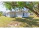 View of backyard showing the side and back of the home with lawn at 3910 E Genesee St, Tampa, FL 33610