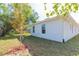 Side of home with lawn and new landscaping featuring fresh mulch at 3910 E Genesee St, Tampa, FL 33610