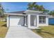 Charming single-story home featuring a well-maintained lawn and a pristine white garage door at 3910 E Genesee St, Tampa, FL 33610