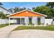 Modern house with gray and orange exterior, landscaped yard, and driveway at 4607 W San Jose St, Tampa, FL 33629