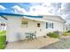 Cozy back patio with table and chairs, next to well-maintained landscaping at 7141 El Matador St, Zephyrhills, FL 33541