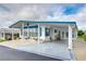 Front view of a white manufactured home with blue trim and a star at 7141 El Matador St, Zephyrhills, FL 33541