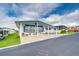 White manufactured home with blue trim and a covered carport at 7141 El Matador St, Zephyrhills, FL 33541