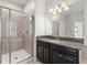 Bathroom with shower, granite countertop, and dark brown vanity at 3147 Calvano Dr, Land O Lakes, FL 34639