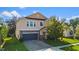 Two-story house with a stone and beige exterior, two-car garage, and landscaping at 3147 Calvano Dr, Land O Lakes, FL 34639