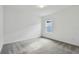 Bright bedroom with grey carpet and a single window at 1686 Fallon Pass, Zephyrhills, FL 33541