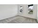Bright bedroom with gray carpet and two windows at 1686 Fallon Pass, Zephyrhills, FL 33541