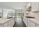 Bright kitchen features white cabinets, an island, and sliding glass doors to backyard at 1686 Fallon Pass, Zephyrhills, FL 33541