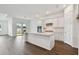 Open concept kitchen with white cabinets, island, and dark hardwood floors at 1686 Fallon Pass, Zephyrhills, FL 33541