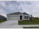 New single-story home with gray siding, two-car garage, and landscaping at 11116 40Th E Ave, Palmetto, FL 34221