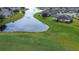 Aerial view of the house and surrounding community featuring a pond and lush greenery at 2403 Richmond Greens Ct, Sun City Center, FL 33573