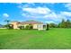 Home with large backyard, lush green grass, and mature landscaping at 2403 Richmond Greens Ct, Sun City Center, FL 33573