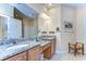 Bathroom featuring double sinks with granite countertops, cabinets, and a large mirror at 2403 Richmond Greens Ct, Sun City Center, FL 33573