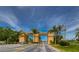 Grand entrance to the community featuring lush landscaping and a secure gated entry at 2403 Richmond Greens Ct, Sun City Center, FL 33573