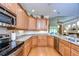 Kitchen featuring maple cabinets, stainless steel appliances, and a view of the Gathering room at 2403 Richmond Greens Ct, Sun City Center, FL 33573